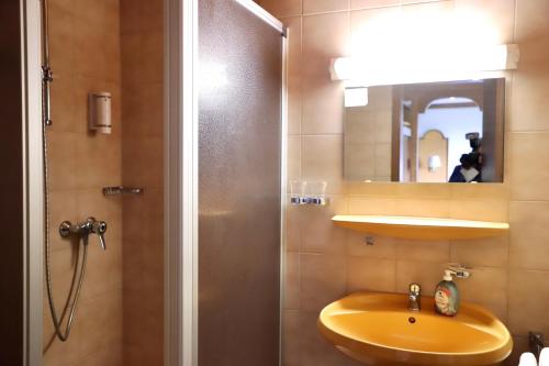 ein Badezimmer mit Waschbecken und Dusche mit Spiegel in der Unterkunft Natur & Wander Hotel Gassbachtal in Grasellenbach