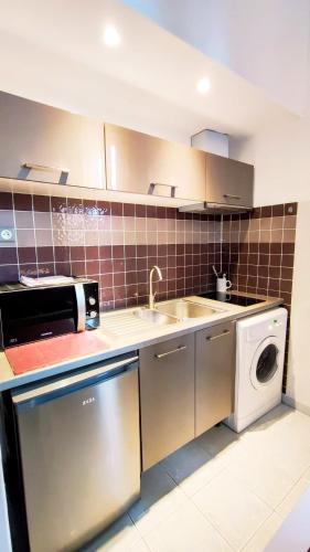 a kitchen with a sink and a washing machine at KosyKasa SPA in Cannes