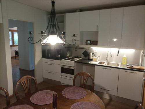 a kitchen with a table and a kitchen with white cabinets at Half Way in Kalaniemi