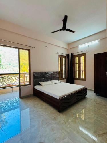 a bedroom with a bed and a ceiling fan at Nirvana Homestay in Chamba