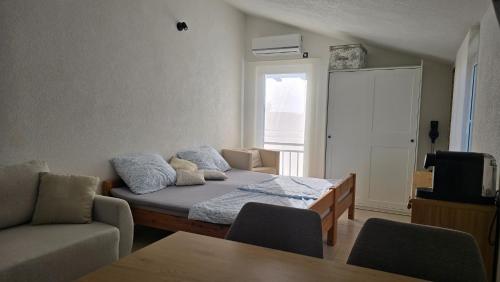 a room with a bed and a couch and a window at Studios Ilic in Seline