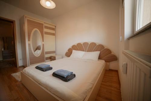 a bedroom with a large bed with two towels on it at Estilo Apartments in Prishtinë