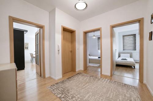 a hallway with white walls and wooden floors and a room at Estilo Apartments in Prishtinë