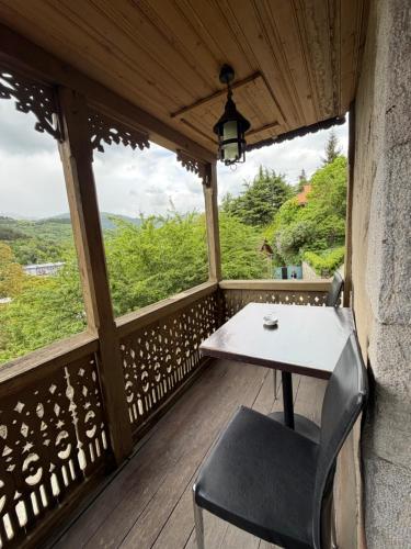 Ein Tisch und ein Stuhl auf einem Balkon mit Aussicht in der Unterkunft Tufenkian Old Dilijan Complex in Dilidschan