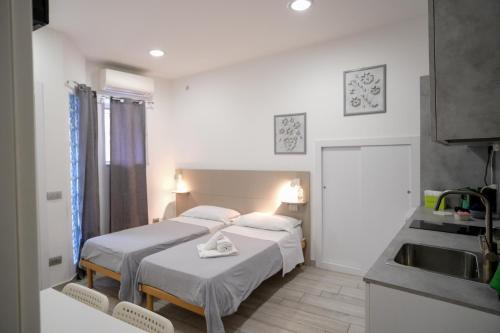 a room with two beds and a sink in it at L'angolo del viaggiatore in Nicosia