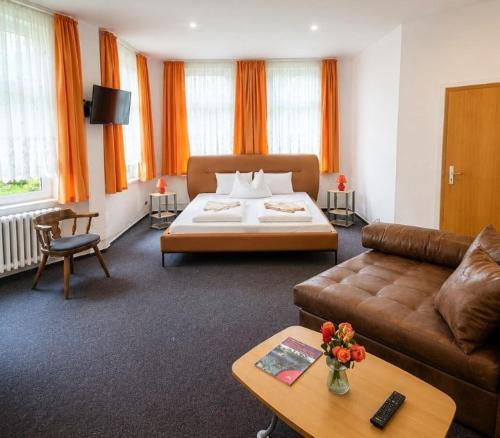 a living room with a bed and a couch at Hotel Waldmühle in Elend