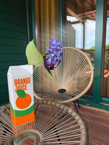 a box of orange juice and a vase of flowers on a chair at Newly renovated Boutique Hotel Giulia Slow Residence in Velden am Wörthersee