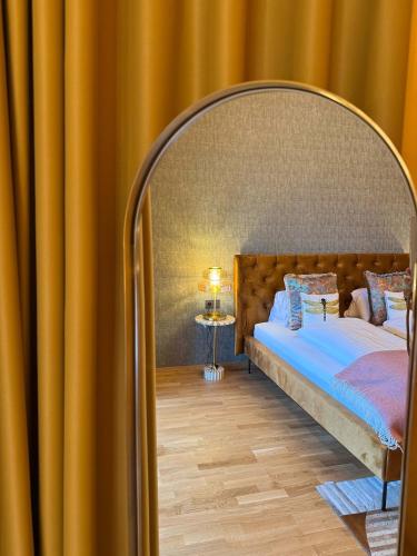 a bedroom with a bed with a large bed frame at Newly renovated Boutique Hotel Giulia Slow Residence in Velden am Wörthersee