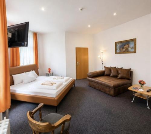 a hotel room with a bed and a couch at Hotel Waldmühle in Elend