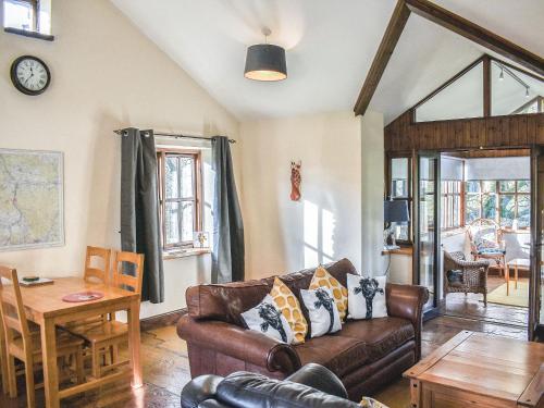 a living room with a couch and a table at Riverbank Cottage-Uk42229 in Low Borrowbridge