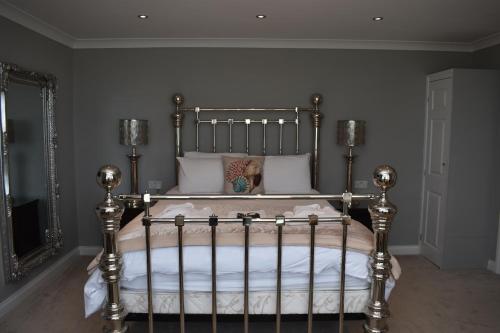 a bedroom with a metal bed with white pillows at The Seacliffe - Whitby in Whitby