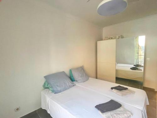 a bedroom with a white bed with blue pillows at Appartement proche gare in Nice