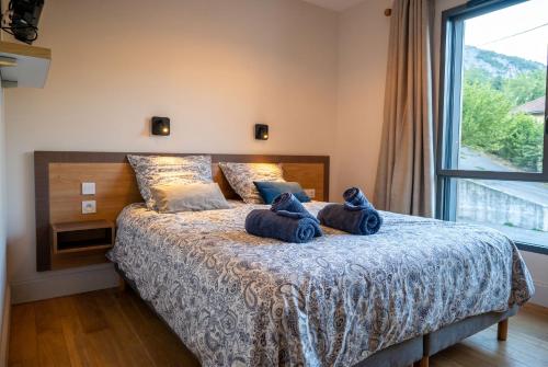 a bedroom with a bed with blue pillows on it at Petit balcon du lac in Lathuile
