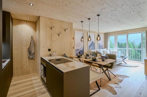 a kitchen and living room with wooden walls and a table at appartamaint tscherv by Arosa Vacations, Exklusive Wohnung im Zentrum mit Blick auf den Untersee und die Berge inkl Parkplatz in Arosa