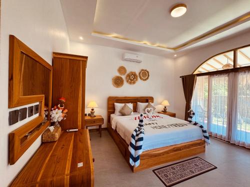a bedroom with a bed and a large window at The Lauk private in Gili Islands