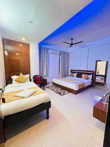 a bedroom with two beds and a blue wall at Hotel Veda Vatica in Varanasi
