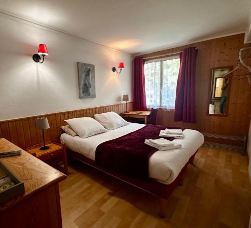 a hotel room with a bed and a window at Hotel Restaurant La Source in La Foux