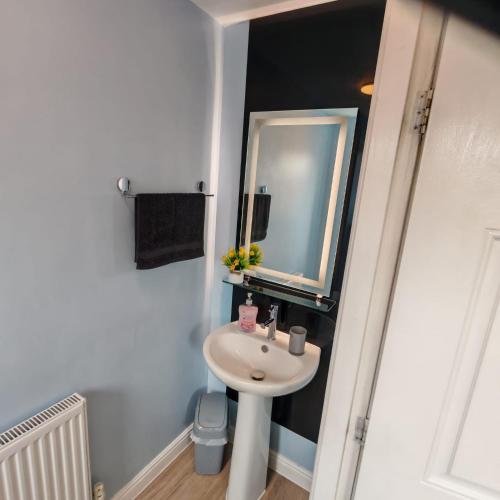 a bathroom with a sink and a mirror at Modern 2 bedroom house, sleeps 5 guests, Free parking in Hull