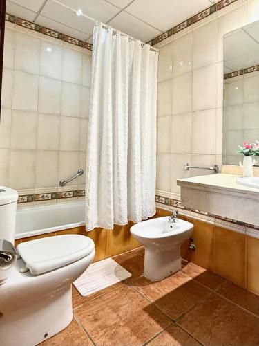 a bathroom with a toilet and a sink and a tub at 525 Aguamarina in San Miguel de Abona