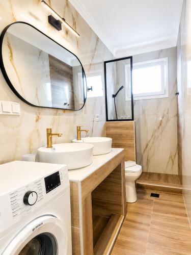 a bathroom with a washing machine and a washer and dryer at Goldtown House in Chrysoupolis