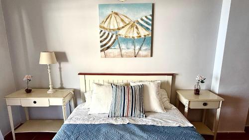 a bedroom with a bed with two night tables and an umbrella at 525 Aguamarina in San Miguel de Abona