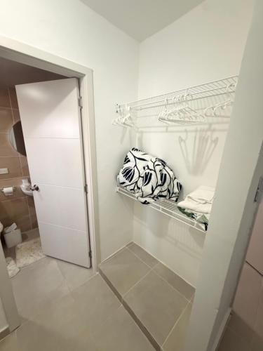 a white closet with a glass door and towels at The Palace in San Isidro