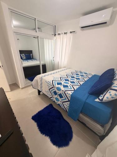 a bedroom with a bed with blue pillows and a mirror at The Palace in San Isidro