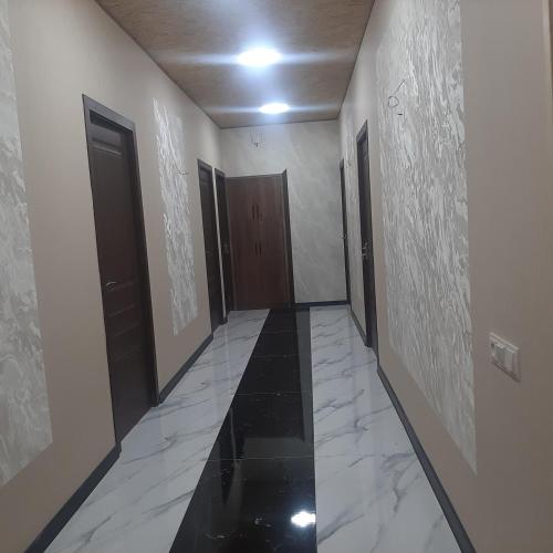 a corridor with doors and marble floors and a hallway with doors at Noy in Goris