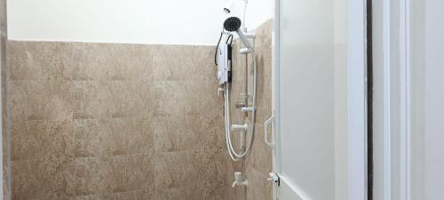 a shower with a shower head on a wall at White House in Puttalam