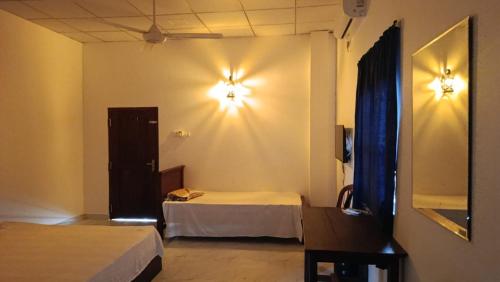 a hotel room with two beds and lights on the wall at White House in Puttalam