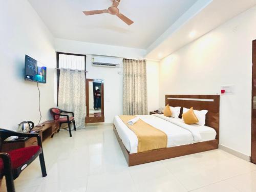 a bedroom with a bed and a desk and a tv at Hotel Veda Vatica in Varanasi