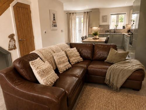 a brown leather couch in a living room at Hawthorn Cottage in Tenby