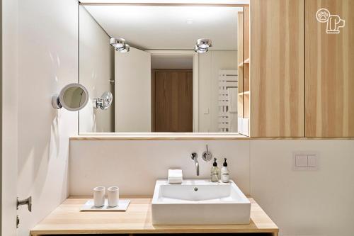 ein Badezimmer mit einem weißen Waschbecken und einem Spiegel in der Unterkunft Inselhouse in Norderney
