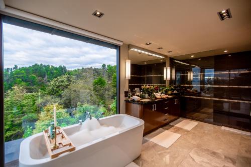 a large bathroom with a tub and a large window at Lodge by the beach - Luxury, Beach access, Ocean views, Private chef in Kaiteriteri
