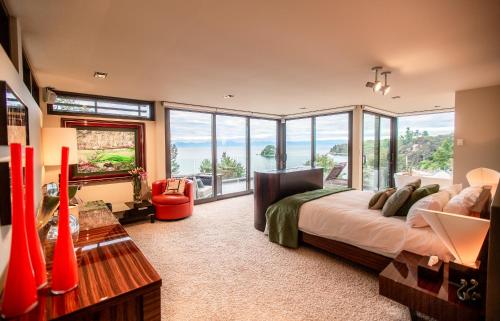 a bedroom with a large bed and a large window at Lodge by the beach - Luxury, Beach access, Ocean views, Private chef in Kaiteriteri