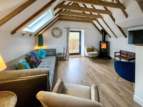 a living room with a couch and a tv at Wellness Cottage At Tomnauld Farm in Pitlochry