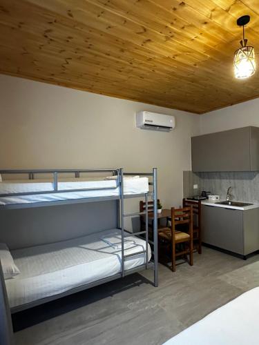a room with two bunk beds and a kitchen at Family Nest in Shtoji i Ri