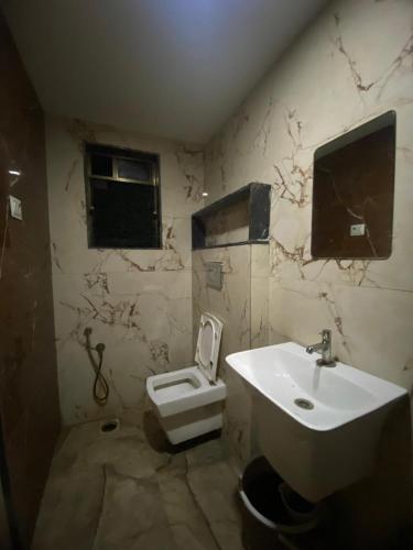 a bathroom with a sink and a toilet at Hotel Bhiwandi Palace Nashik Highway Rd in Bhiwandi