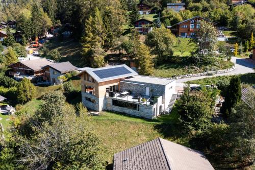 an aerial view of a house with a solar roof at Villa moderne avec Jacuzzi - ski - golf in Icogne