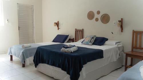 two beds in a hotel room with towels on them at Pousada Sorriso da Mata.. in Alter do Chao
