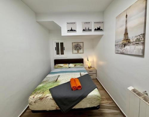 a bedroom with a bed with an orange pillow on it at close to beach and 15 mints to la rambla by tren in Sant Adria de Besos