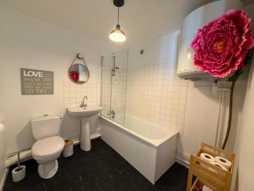 a bathroom with a toilet a sink and a bath tub at So Chic Romance au pied du Château in Sedan