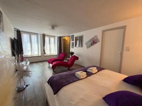 a bedroom with two beds and two red chairs at So Chic Romance au pied du Château in Sedan