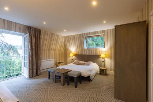 a bedroom with a bed and a table and a window at Résidence du Bas Mont in Moulay
