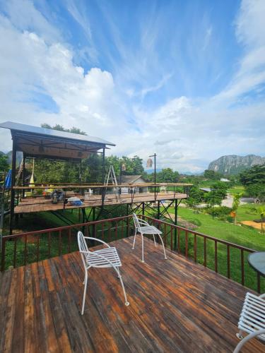 two chairs sitting on a deck with a view at SKYLINE vangvieng Resort in Vang Vieng