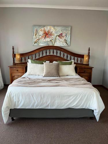 a bedroom with a large bed with a wooden headboard at Eagles Nest in Sedgefield