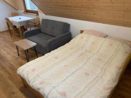 a small bedroom with a bed and a chair at Kubanka dom pokoje apartamenty in Płocice