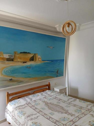 a painting on the wall of a bedroom with a bed at Appartement S2 Hammamet Centre in Hammamet