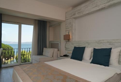a bedroom with a large bed and a balcony at Kırtay Hotel Erdek in Erdek