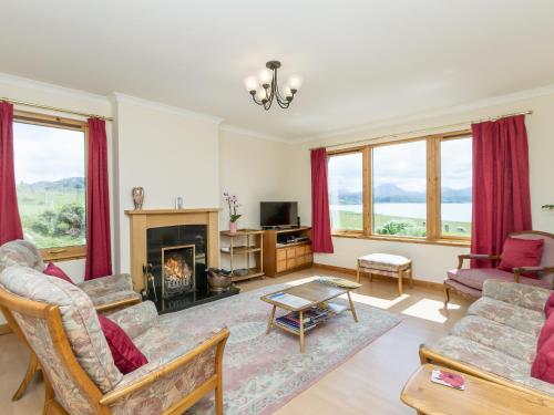 a living room with a fireplace and red curtains at Ach-Na-Clachan in Gairloch